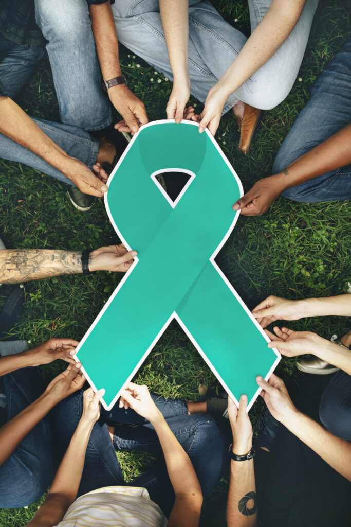 group people holding green colored ribbon scaled.jpg