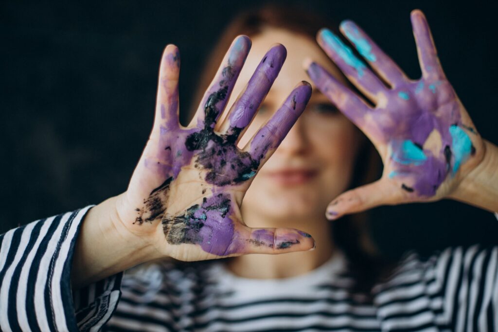 woman artist with with painted hands scaled.jpg